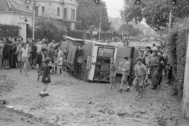Tranvía volcado ante el sanatorio 18 de julio y calles embarradas por las inundaciones del 29 de octubre de 1955. Málaga, España.