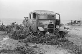Vehículo del sanatorio Francisco Franco en la playa de La Caleta, embarrada por las inundaciones del 29 de octubre de 1955. Málaga, España.