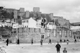 La Alcazaba. En primer término, construcción de la Casa de la Cultura. Calle Alcazabilla. Hacia 1950. Málaga, España.