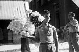 Biznaguero, José Gallardo Romero, en Puerta Nueva, al fondo calle García Briz. Década de 1940. Málaga, España.