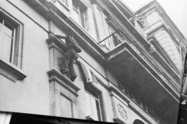 Manifestación por la autonomía de Andalucía. 1977-12-04. Málaga, España. 1.5. Juan Manuel Trinidad Berlanga asciende para poner la bandera andaluza en el balcón de Diputación.
