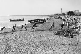 Playas de la Malagueta. Pescadores arrastrando las redes del copo en la orilla del mar. Málaga, España. 01