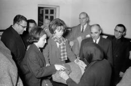 Ramón Castilla Pérez y Francisco García Grana juntos a dos mujeres en la recogida y reparto de ropas y mantas para los afectados del temporal de viento. Málaga. Enero de 1963